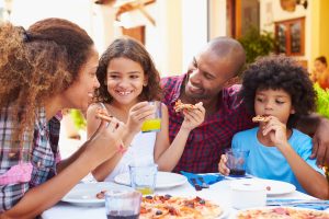 Famille qui mange de la pizza au restaurant familial le Saint-Germain.